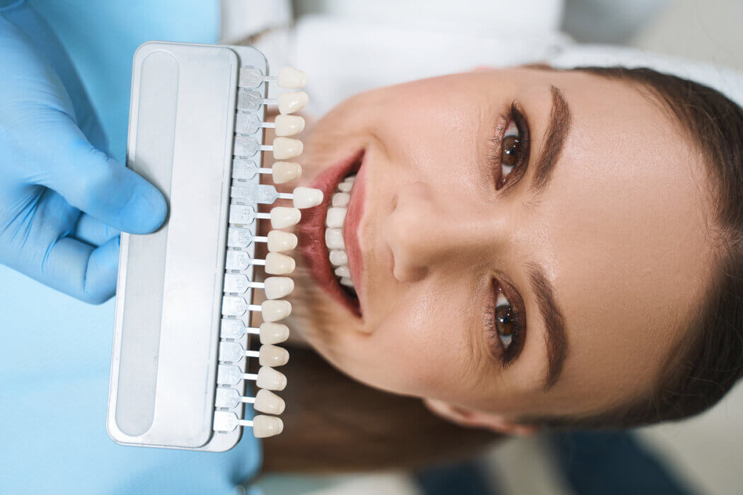 A young woman at a dental office considering cosmetic dental procedures like dental veneers or teeth whitening
